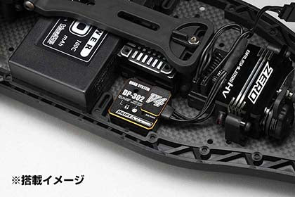 Close-up of a Yokomo ST Gyro[Black]w/EP Adj.for Use w/2-3ch with various components on a white background