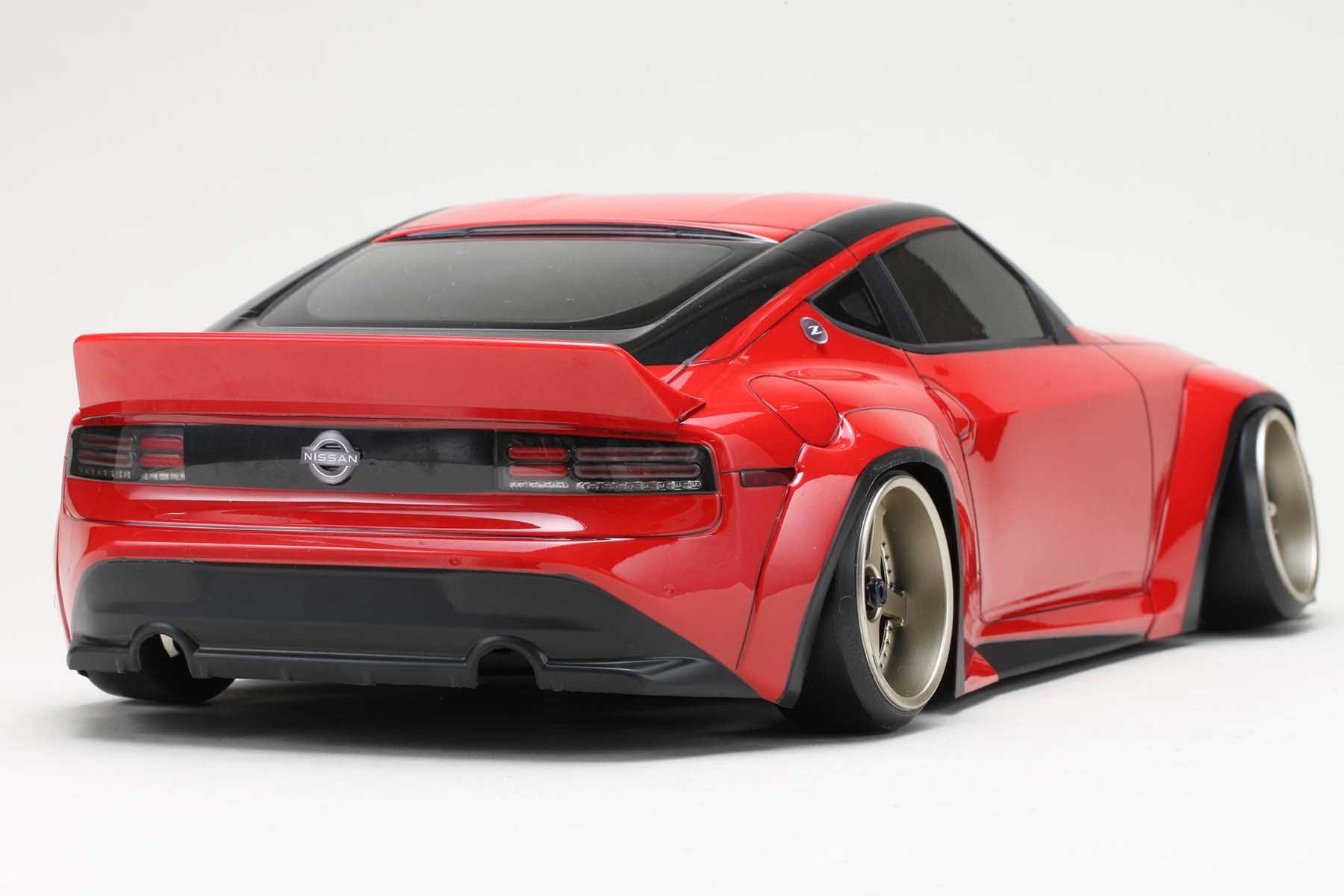 Back view of a fully assembled PANDEM NISSAN FAIRLADY Z RZ34 Body in red on a white background